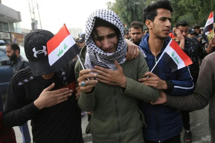 An Iraqi youth cries during the funeral procession of a prominent civil society activist who was shot dead the previous night
