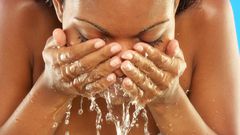 African woman washing her face