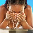 African woman washing her face