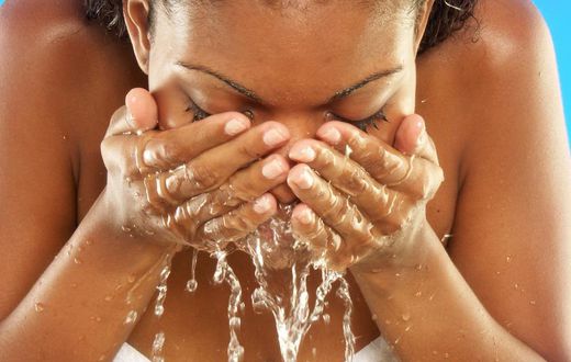 African woman washing her face