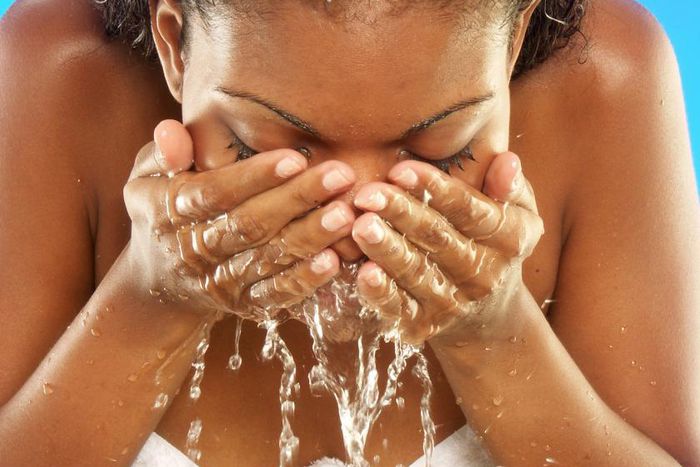 African woman washing her face