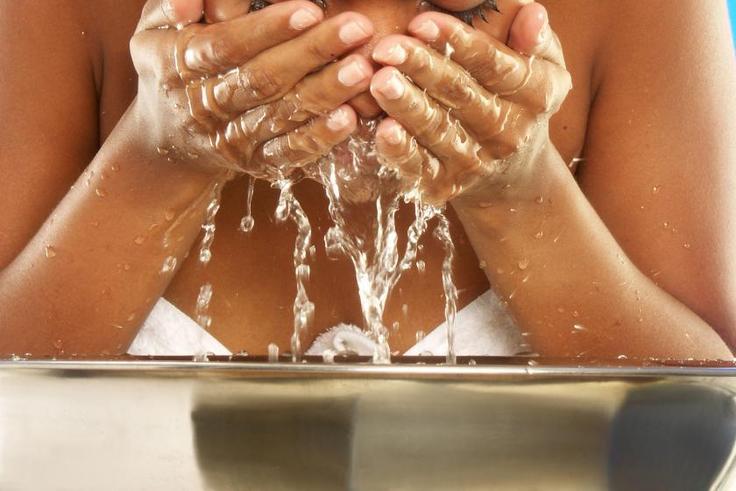 African woman washing her face