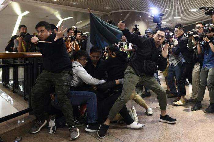 Police react as anti-government protesters throw an umbrella at them on Christmas Eve in the Tsim Sha Tsui district of Hong Kong