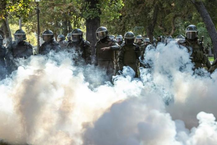 Demonstrators clash with Chilean riot police during a protest against Chilean President Sebastian Pinera's government in Santiago, on March 13, 2020.
