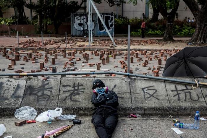A Hong Kong pro-democracy protester sleeps on a barricaded street outside a university