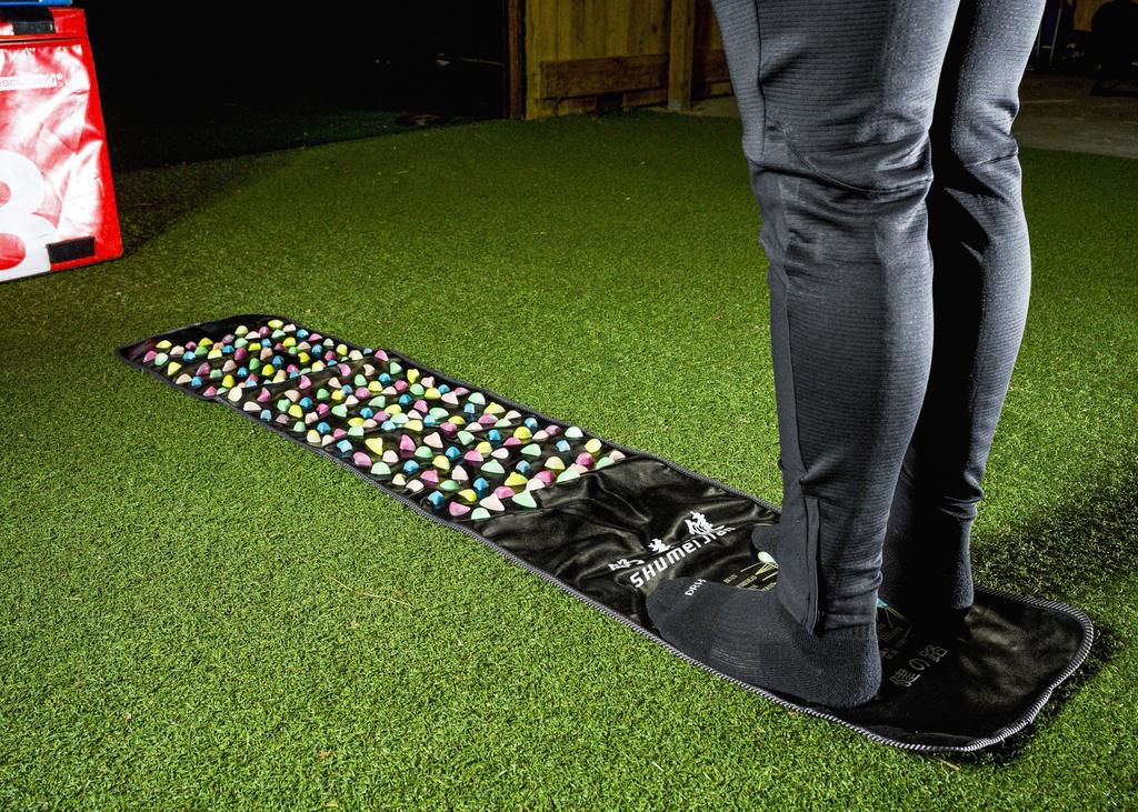 Pete Alonso's feet on a rock mat, a mat with rocks that poke out of it. Alonso is barefoot.