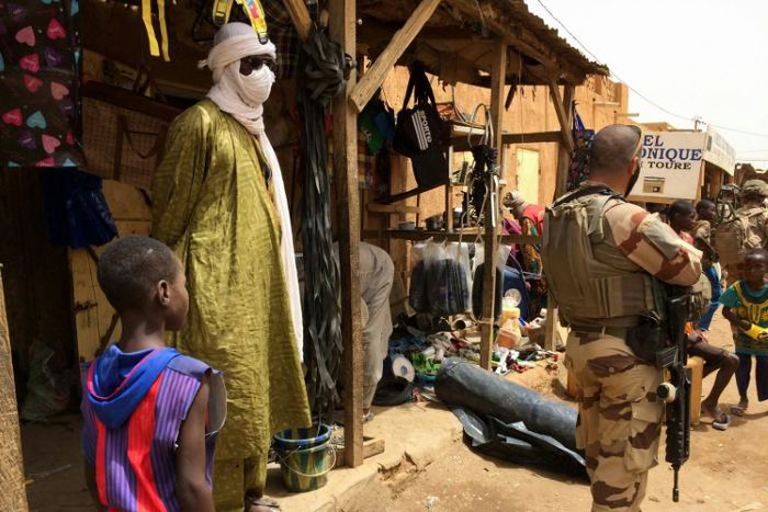 Far from home: A member of France's Barkhane force patrols the market in Menaka, northeastern Mali