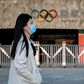 Passers-by at Beijing's Olympic Park wear protective face masks as the coronavirus pandemic causes problems around the world