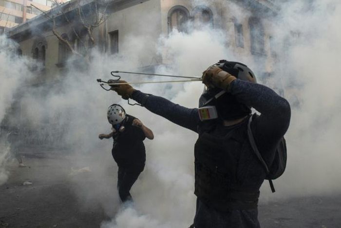 A demonstrator aims a sling at the police during a protest against Chilean President Sebastian Pinera's government in Santiago