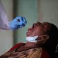 Open wide: A health worker takes a swab during a coronavirus test campaign in the Nigerian capital Abuja