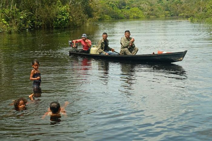 Fishermen and children are seen in the river in Bauana, a village in the heart of the Brazilian Amazon, on March 14