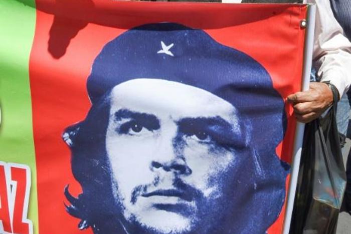 A supporter of Bolivian ex-President Evo Morales holds banner with an image of revolutionary leader Ernesto 'Che' Guevara during a demonstration Monday in La Paz