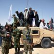 Afghan Taliban militants and residents stand on an Afghan National Army armoured Humvee as they celebrate a ceasefire in Kandahar province
