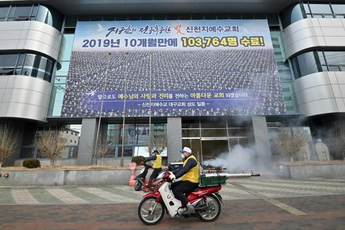 South Korean health officials spray disinfectant in front of the Daegu branch of the Shincheonji Church of Jesus in an attempt to combat the COVID-19 coronavirus outbreak