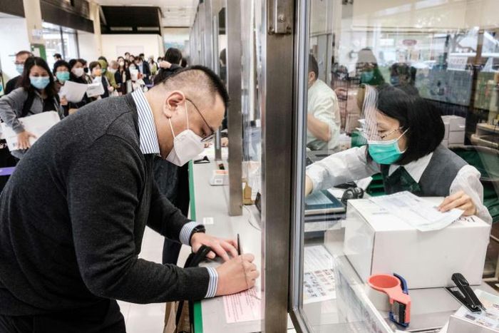 Hong Kongers like Adrian W. Chan (L) are now sending parcels of face masks and other supplies to friends and relatives abroad as the virus spreads