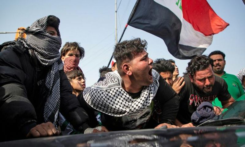 Angry Iraqi demonstrators mourn the killing of female activist and paramedic Janat Madhi, in Basra on Tuesday night, part of an upsurge of violence against the three-month-old protest movement