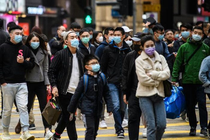 Pedestrians wearing face masks cross a road during a Lunar New Year of the Rat public holiday in Hong Kong on January 27, 2020, as a preventative measure following a coronavirus outbreak which began in the Chinese city of Wuhan