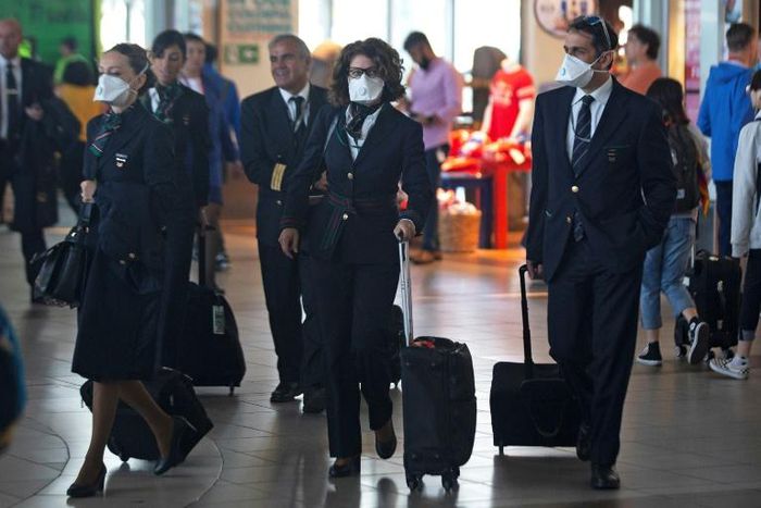 Airline staff wear protective face masks at Santiago international airport, Chile, on March 14, 2020.