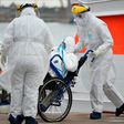 Medical workers transfer a passenger with COVID-19 from the Greg Mortimer cruise liner to an ambulance at Montevideo's port on April 8, 2020