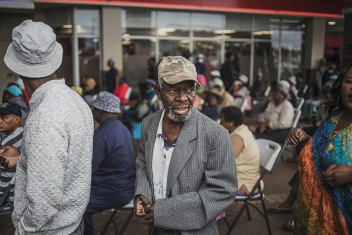 An elderly man from Soweto queues to collect his social grant