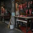 A woman tends her meat stall in Wuhan, where the coronavirus started. Life is slowly returning to normal in the city, but fears remain
