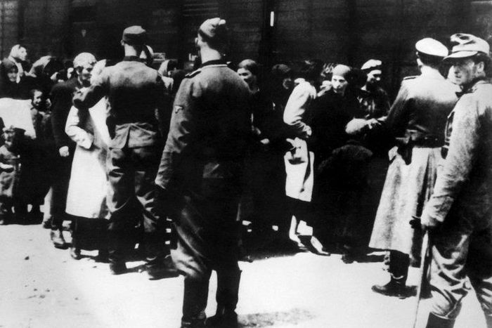 SS soldiers lead newly arrived prisoners to the gas chambers at the Auschwitz concentration camp. The death camp remains an enduring symbol of the Holocaust.
