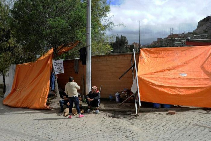 Opponents of Bolivian ex-president Evo Morales camp at the entrance of the La Rinconada gated community in La Paz, where the Mexican embassy is located and where some members of Morales' government have taken refuge
