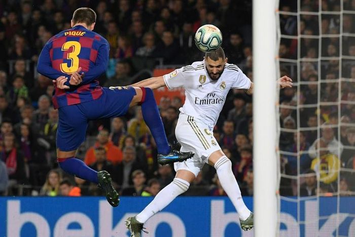 Barcelona defender Gerard Pique (left) challenges Real Madrid's Karim Benzema (right) during the Clasico on Wednesday.