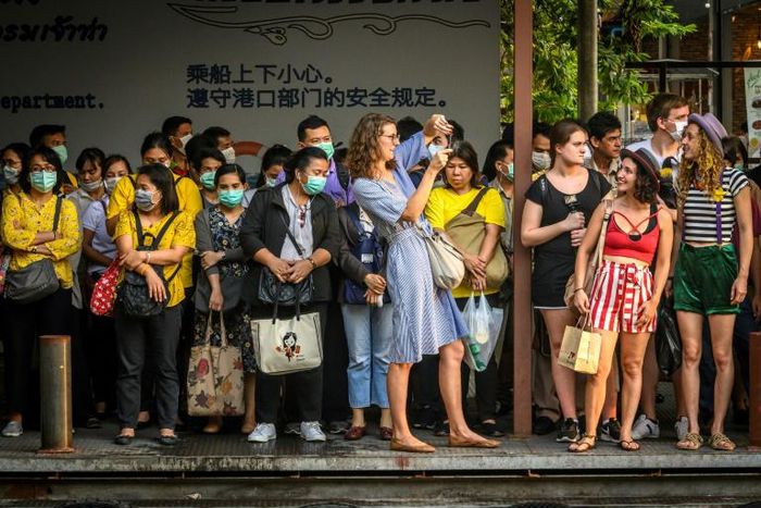 Foreign tourists take pictures next to Thai commuters with face masks as they wait for a canal boat in BangkokA Thai man has died from complications doctors say were due to the deadly coronavirus, though health officials were reluctant on March 2 to co...