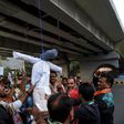 Demonstrators from the National Congress Party hang and beat a dummy of a rapist as they protest against sexual violence