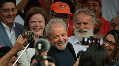 Former Brazilian president Luiz Inacio Lula da Silva smiles next to his girlfriend after leaving the federal police headquarters in Curitiba, where he was serving a sentence for corruption and money laundering