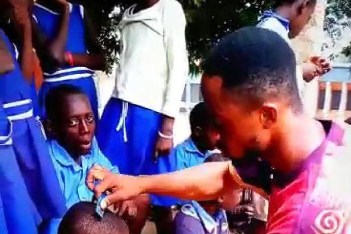 Dancing teacher Percy Sackey cuts his pupils hair