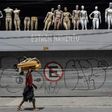 A homeless walks past a closed parking lot and mannequins in downtown Sao Paulo, Brazil, after the city government decreed the closure of shops and stores as a precautionary measure against the spread of the novel coronavirus COVID-19, on March 24, 202...