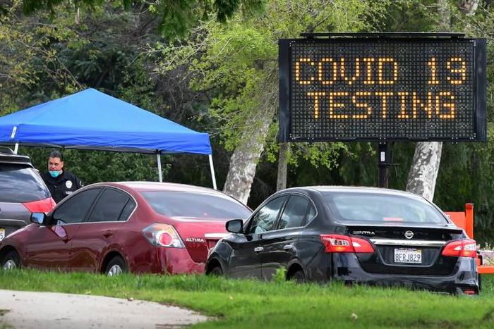 A police officer mans the entrance to a coronavirus (COVID-19) testing center in Hansen Dam Park in Pacoima, California