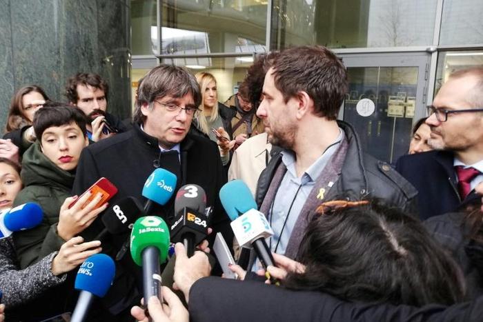 Former Catalan regional president Carles Puigdemont (C-L) and his health minister Toni Comin (C-R) talk to the press after receiving their badges as accredited members of the European Parliament on December 20, 2019 in Brussels