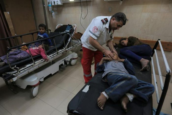 A Palestinian medic tends to surviving children from the Abu Malhous family which lost eight members to an Israeli strike on their Gaza home that the military says targeted an Islamic Jihad commander