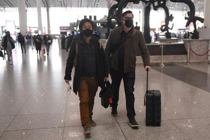 Wall Street Journal reporters Philip Wen (left) and Josh Chin walk through Beijing Capital Airport after being expelled by Chinese authorities