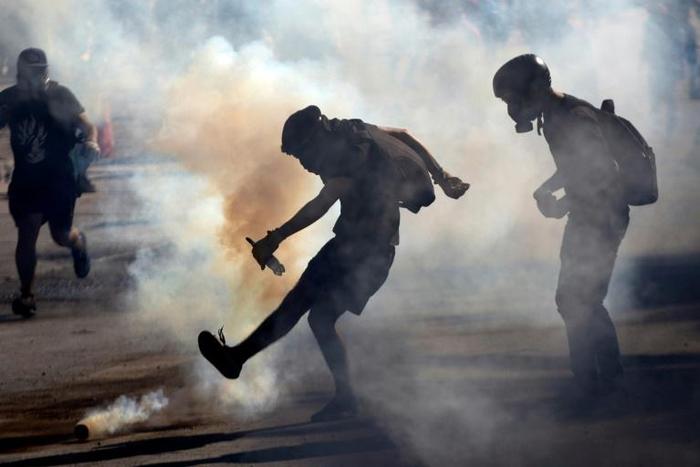 Demonstrators clash with riot police during a protest against the government in Santiago on November 26, 2019