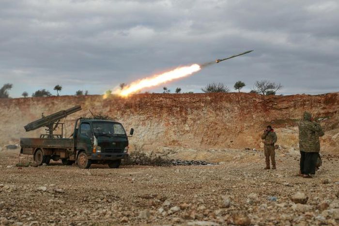 Syrian rebel fighters fire a rocket in northwestern Syria where battles with government forces have intensified in recent weeks