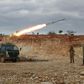 Syrian rebel fighters fire a rocket in northwestern Syria where battles with government forces have intensified in recent weeks