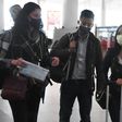 Wall Street Journal reporters Julie Wernau (L), Stu Woo (C) and Stephanie Yang walk through Beijing Capital Airport before departing