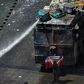 A demonstrator stands in front of police water cannon in Santiago, Chile, which has been rocked by protests