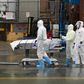 Medical personnel move a deceased patient to a refrigerated truck serving as a makeshift morgue in Brooklyn