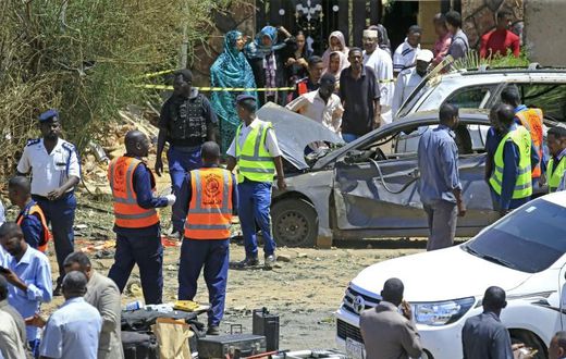 Sudanese rescue teams and security forces circle damaged vehicles at the site of a bomb attack targeting the convoy of Prime Minister Abdalla Hamdok, who survived the attack unharmed