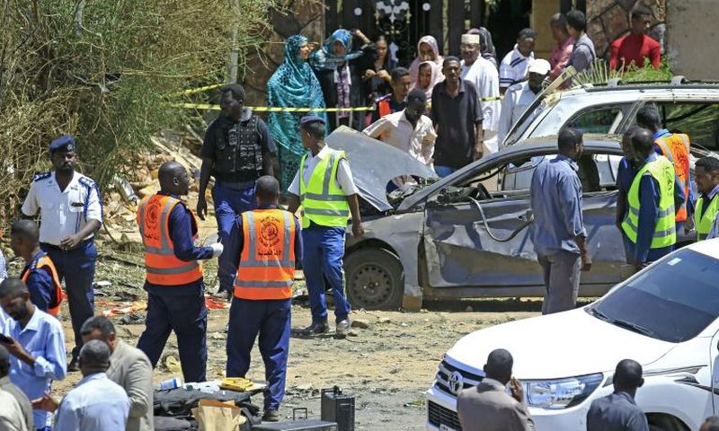 Sudanese rescue teams and security forces circle damaged vehicles at the site of a bomb attack targeting the convoy of Prime Minister Abdalla Hamdok, who survived the attack unharmed