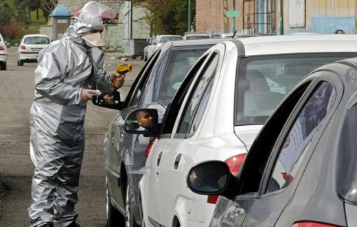 Members of the Iranian Red Crescent test people for coronavirus symptoms stopped on the Tehran to Alborz highway under a government order to screen every person for the illness