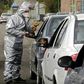 Members of the Iranian Red Crescent test people for coronavirus symptoms stopped on the Tehran to Alborz highway under a government order to screen every person for the illness