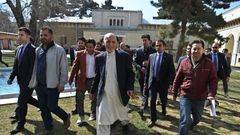 Afghan President Ashraf Ghani (C), walking with journalists after a press conference at the presidential palace, said he would not commit to a clause in the US-Taliban deal calling for a massive prisoner exchange