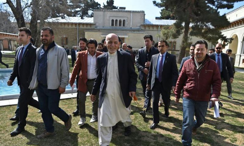 Afghan President Ashraf Ghani (C), walking with journalists after a press conference at the presidential palace, said he would not commit to a clause in the US-Taliban deal calling for a massive prisoner exchange