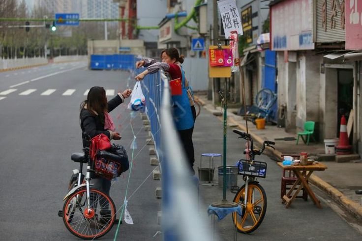 Barriers to stop the spread of the coronavirus in Wuhan have divided communities